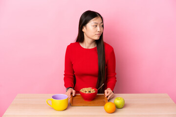 Young Chinese girl  having breakfast in a table . Portrait