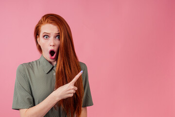 redhair ginger woman amazed and surprised in cotton green white peas dress in pick background studio