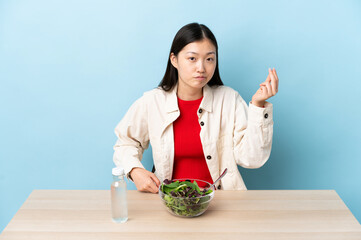 Young Chinese girl eating a salad making Italian gesture