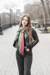 Portrait of a young girl who poses while walking in cloudy weather