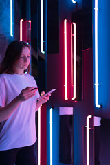 A woman holds a credit card and a phone in cyberspace. Online shopping and purchase