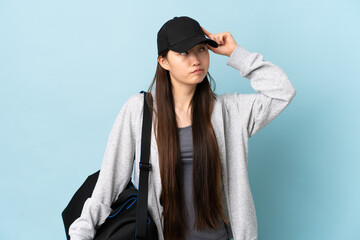 Young sport Chinese  woman with sport bag over isolated blue background making the gesture of...