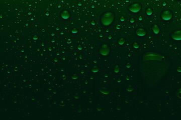Sparkling drops of water on a color background. Selective focus. Green