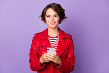 Photo of young attractive girl happy positive smile chat type sms cellphone isolated over purple color background