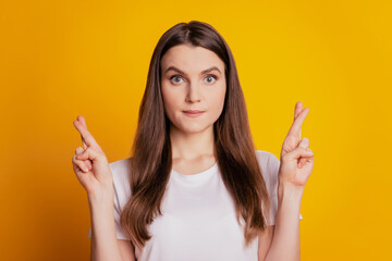 Photo of lady crossed fingers hope wear white t-shirt posing on yellow background