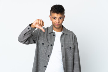 Young brazilian man isolated on white background showing thumb down with negative expression