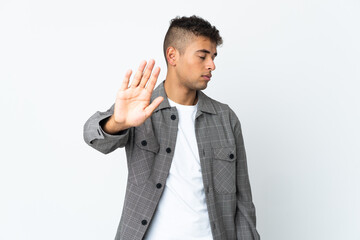 Young brazilian man isolated on white background making stop gesture and disappointed