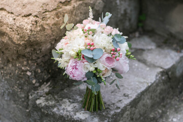 Fototapeta na wymiar Pink wedding bouquet, composed of roses, freesias, peonies, hypericum, astilba and eucalypthus.