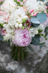 Pink wedding bouquet, composed of roses, freesias, peonies, hypericum, astilba and eucalypthus. Close up.