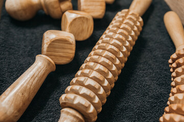 Wooden massage tools to stimulate the lymphatic system and improve circulation. Treatment to eliminate cellulite. Swedish cup, wooden roller with cubes, wooden paddle, wooden roller