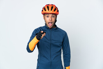 Young cyclist Brazilian man isolated on white background surprised and pointing front - obrazy, fototapety, plakaty