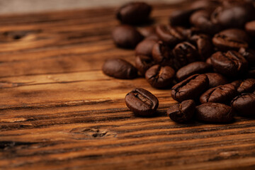 Roasted coffee beans on the old dark wooden background for wallpaper or decor