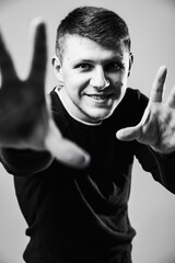 man posing and smiling looking through the hands