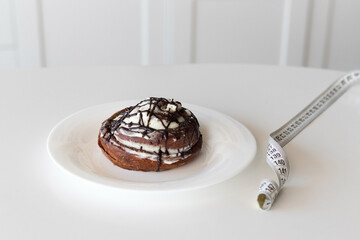 Diet concept, cinnamon roll and waist meter