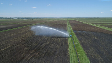 Aerial view of Crop Irrigation using the center pivot sprinkler system. An irrigation pivot watering agricultural land. Irrigation system watering farm land.