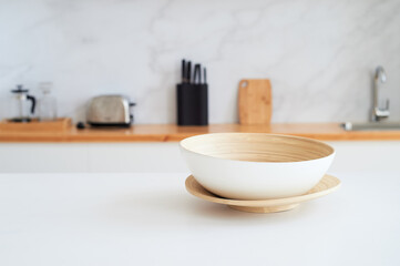 White countertop with a large light bowl for salad. Kitchen in the studio. Decor of a stylish room.