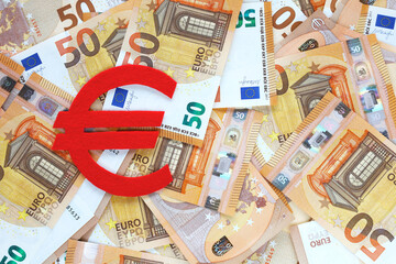 Red felt Euro currency sign on 50 fifty euro banknotes background. Financial, bank, money, economy, business concept. Place for text.