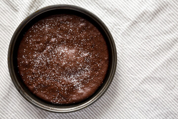 Homemade Chocolate Cake with Powdered Sugar, top view. Flat lay, overhead, from above. Copy space.
