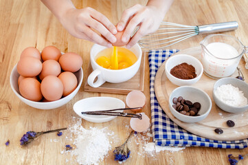 Man in the kitchen cooking a dough. Hands breaks an egg into a bowl ,hands pouring bitten egg ,Baking concept