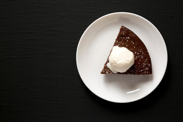 Homemade Chocolate Cake with Ice Cream on a black background, top view. Flat lay, overhead, from above. Space for text.