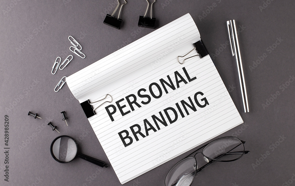 Poster text personal branding on notebook and office tools on gray desktop