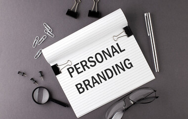 Text PERSONAL BRANDING on Notebook and office tools on gray desktop