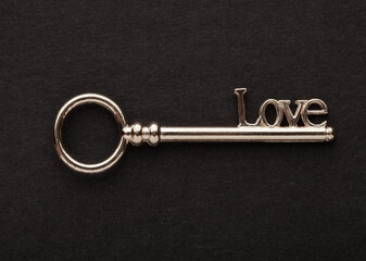 Decorative metal key on the empty black background