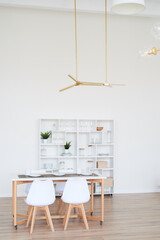 Light white kitchen with white chairs. Lunch area. A large light space.