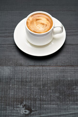 Cup of espresso coffee on dark wooden background