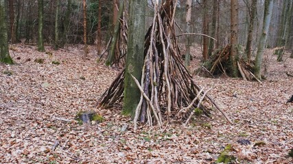 Creepy Abandoned Forest Outpost Camp with Sheds and Huts Built with Wooden Branches and Sticks

