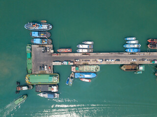 Aerial top view of fisherman dock which has many ships anchoring for transport supplies inland