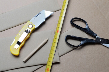 tools for working with cardboard laid out on a table with cardboard scraps.