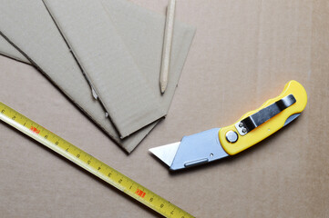 tools for working with cardboard laid out on a table with cardboard scraps.