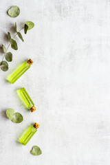 Glass bottles of herbal essential oil with eucalyptus leaves. Natural cosmetics products