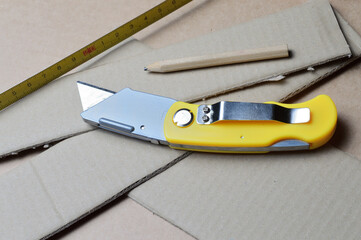 tools for working with cardboard laid out on a table with cardboard scraps.