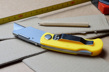 tools for working with cardboard laid out on a table with cardboard scraps.