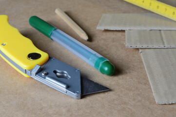 tools for working with cardboard laid out on a table with cardboard scraps.