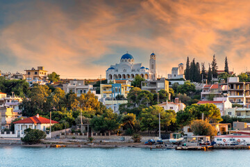 Salamis Island, Attica, Greece. The Assumption of Virgin Mary holy church in Salamis island, as seen from the ferry boat (route Piraeus - Salamis). Sunset, colorful cloudy sky - obrazy, fototapety, plakaty