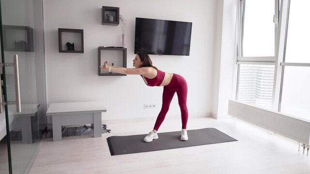Beautiful woman exercising, doing warmup at home