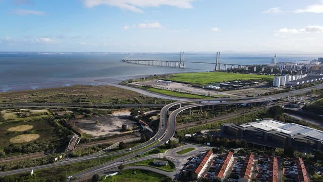 Aerial view of Vasco da Gama bridge crossing the Tagus River in oriente district with industrial area in foreground, Lisbon, Portugal.