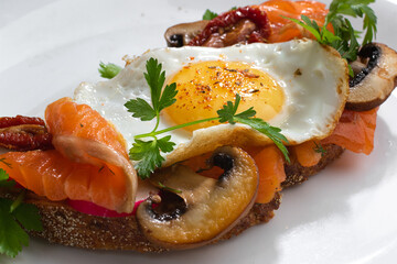 Egg Sandwiches with salmon and mushrooms for healthy breakfast on white background.Close up.