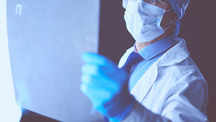 Young doctor looking X-Ray image on isolated white background