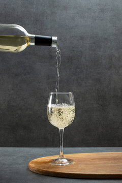 White wine is being poured in a glass, wine tasting concept
