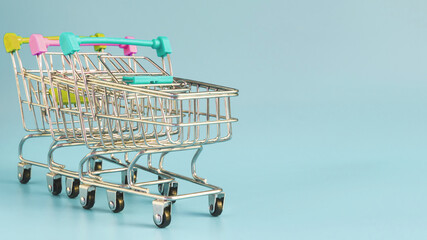 empty metal shopping carts on a colored background space for a text concept