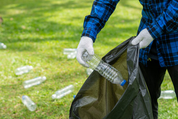 Man picking up plastic bottle, garbage collecting in a forest cleaning planet, help garbage collection charity environment