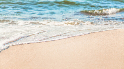 Fototapeta na wymiar the waves of the sea on the sandy beach on a sunny day