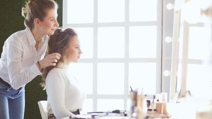 Fototapeta premium make up artist doing professional make up of young woman