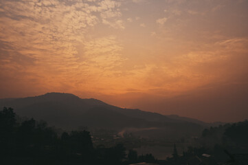 Golden hour orange sky at small village around the lake and surrounding by mountain
