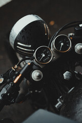 Vintage black motorcycle speedometer and handlebars, top-down view