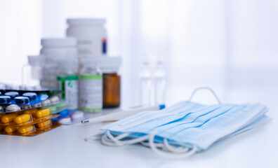 medicine background with packs of pills, glass bottle, medical masks and ampoules on the white background